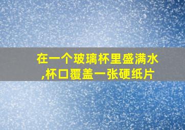 在一个玻璃杯里盛满水,杯口覆盖一张硬纸片