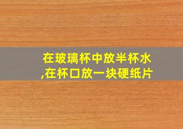 在玻璃杯中放半杯水,在杯口放一块硬纸片